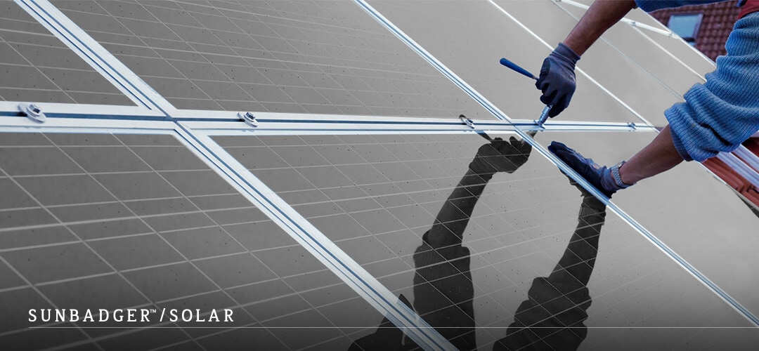 Person installing black solar panels to roof