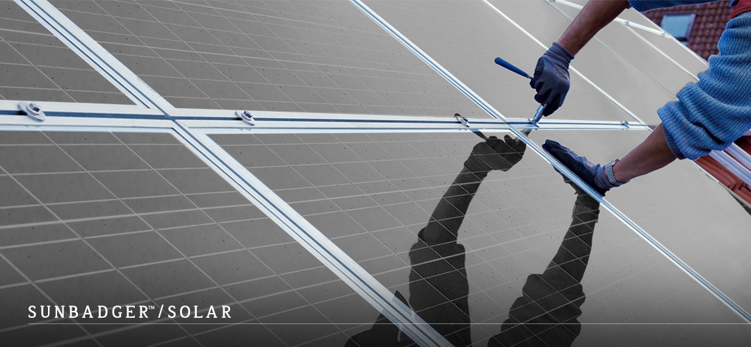 A man is installing solar panels made from TPT which is the most popular backsheet material for solar panels.