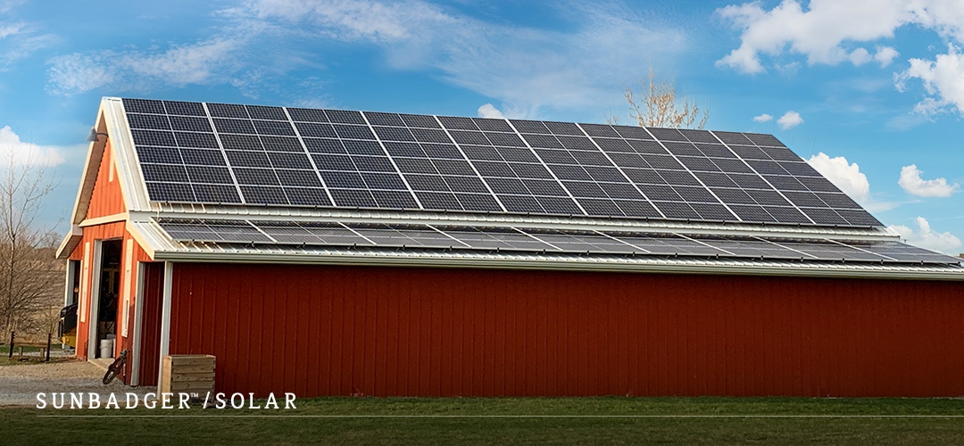 Red barn with solar panels across the roof.
